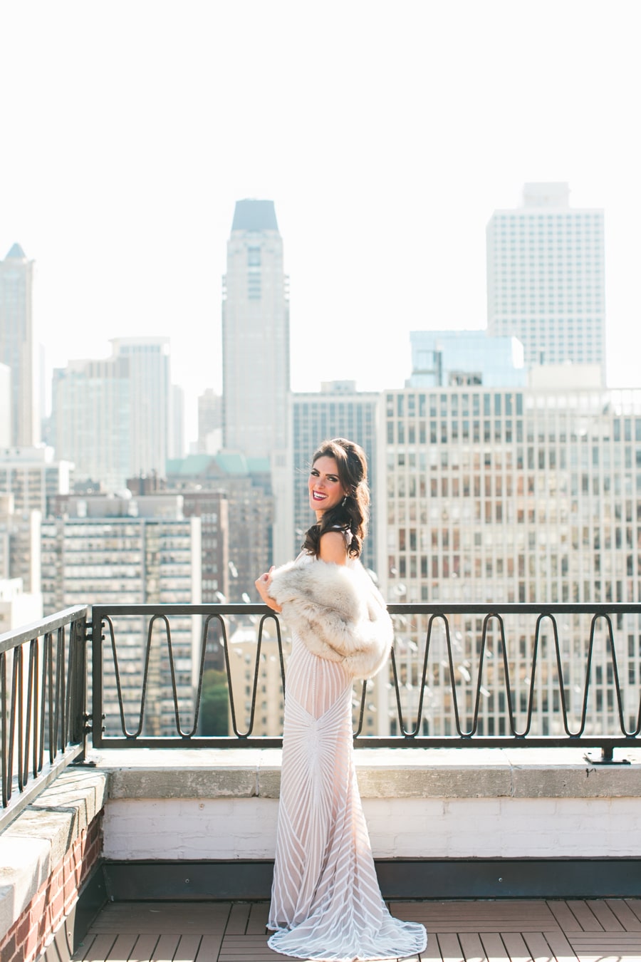 A bride poses on a Chicago rooftop while wearing a vintage fur.