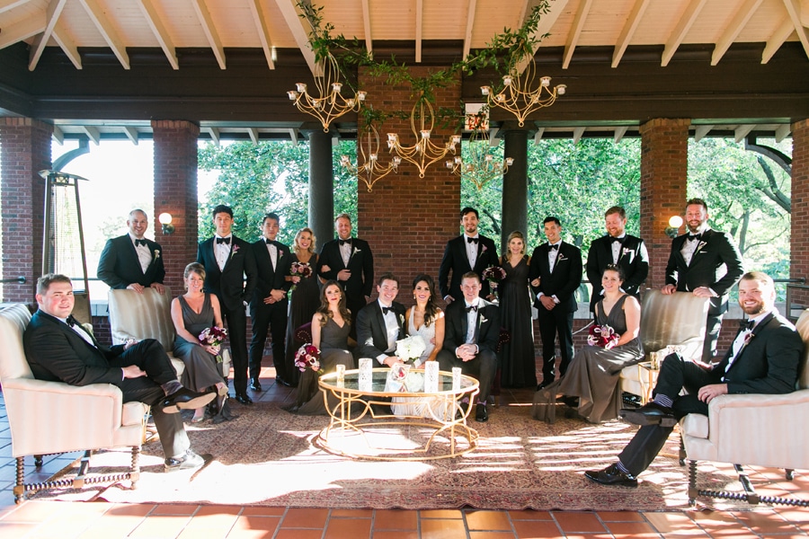 A large wedding party poses on the loggia of Cafe Brauer.