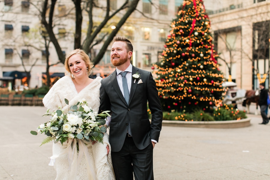 A bride and groom take a stroll by the historic Water Tower around Christmas time in Chicago.