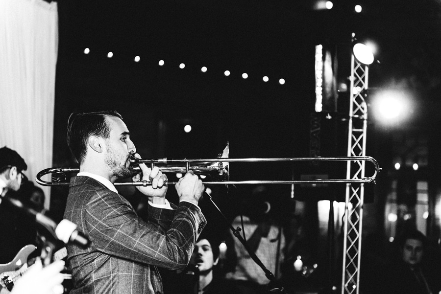 A black and white photo of a trombone player in the wedding band.