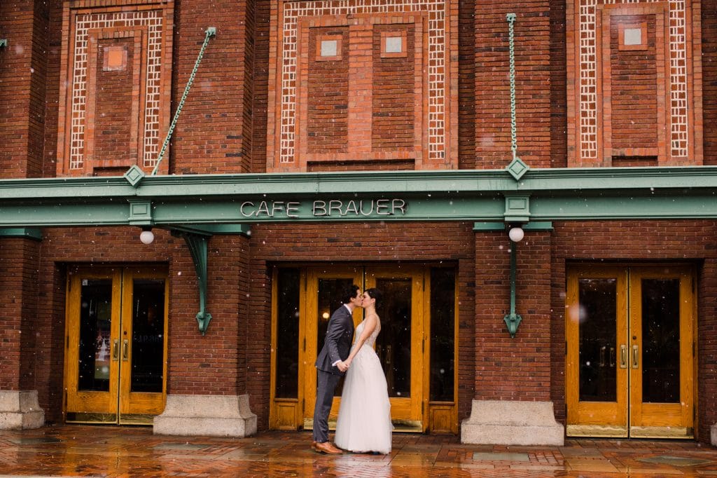 A snowy wedding day portrait outside of Cafe Brauer.
