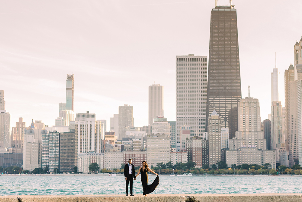 Engaged couple pose in front of Chicago skyline at North Avenue Beach