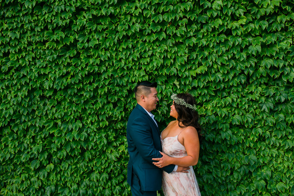 Couple pose in front of ivy covered wall for Chicago engagement photo