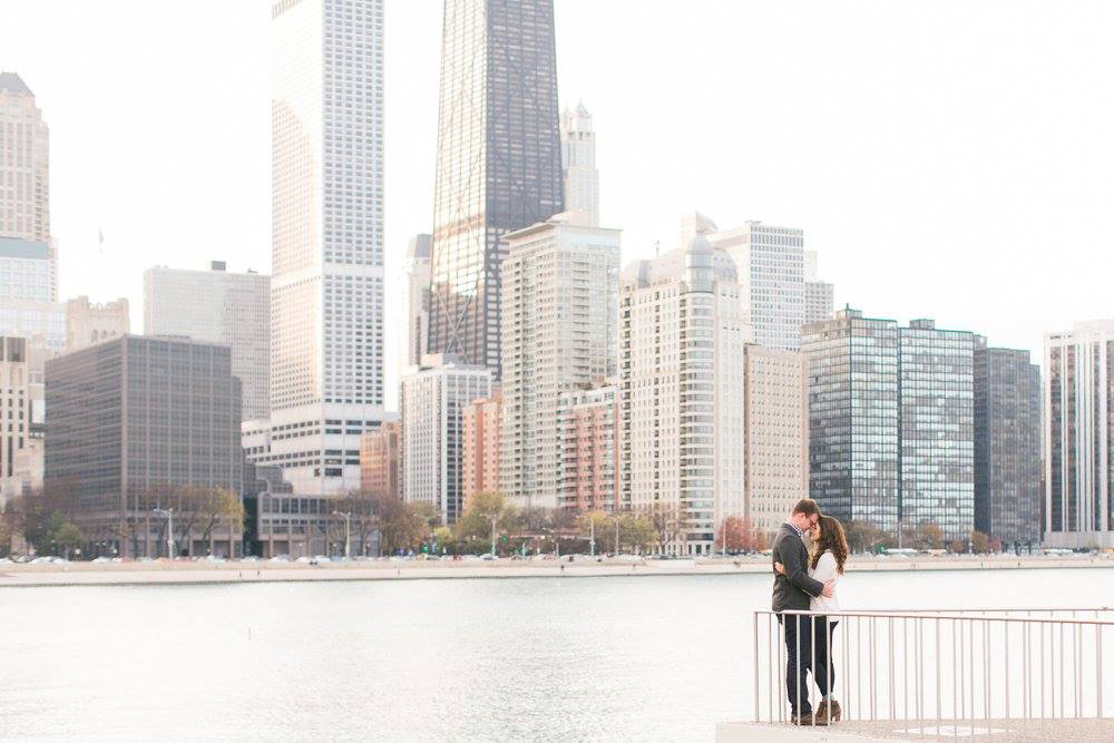 Couple pose at sunset in front of Chicago skyline at Olive Park