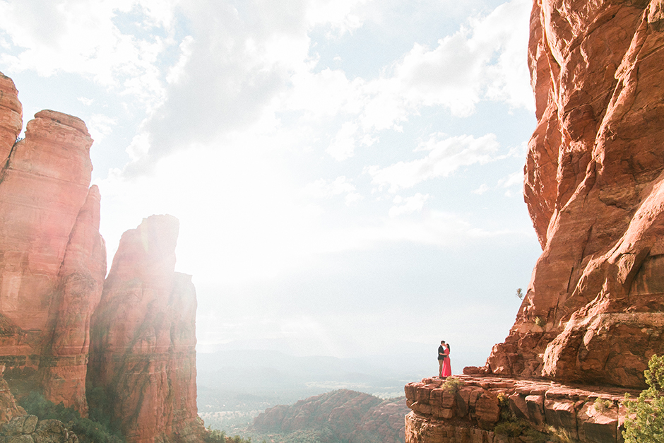 Engaged couple pose on top of Cathedral Rock in Sedona