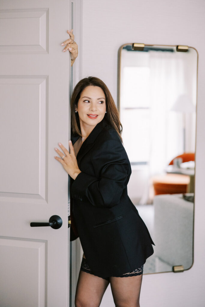 Woman wearing black blazer standing in doorway boudoir photo