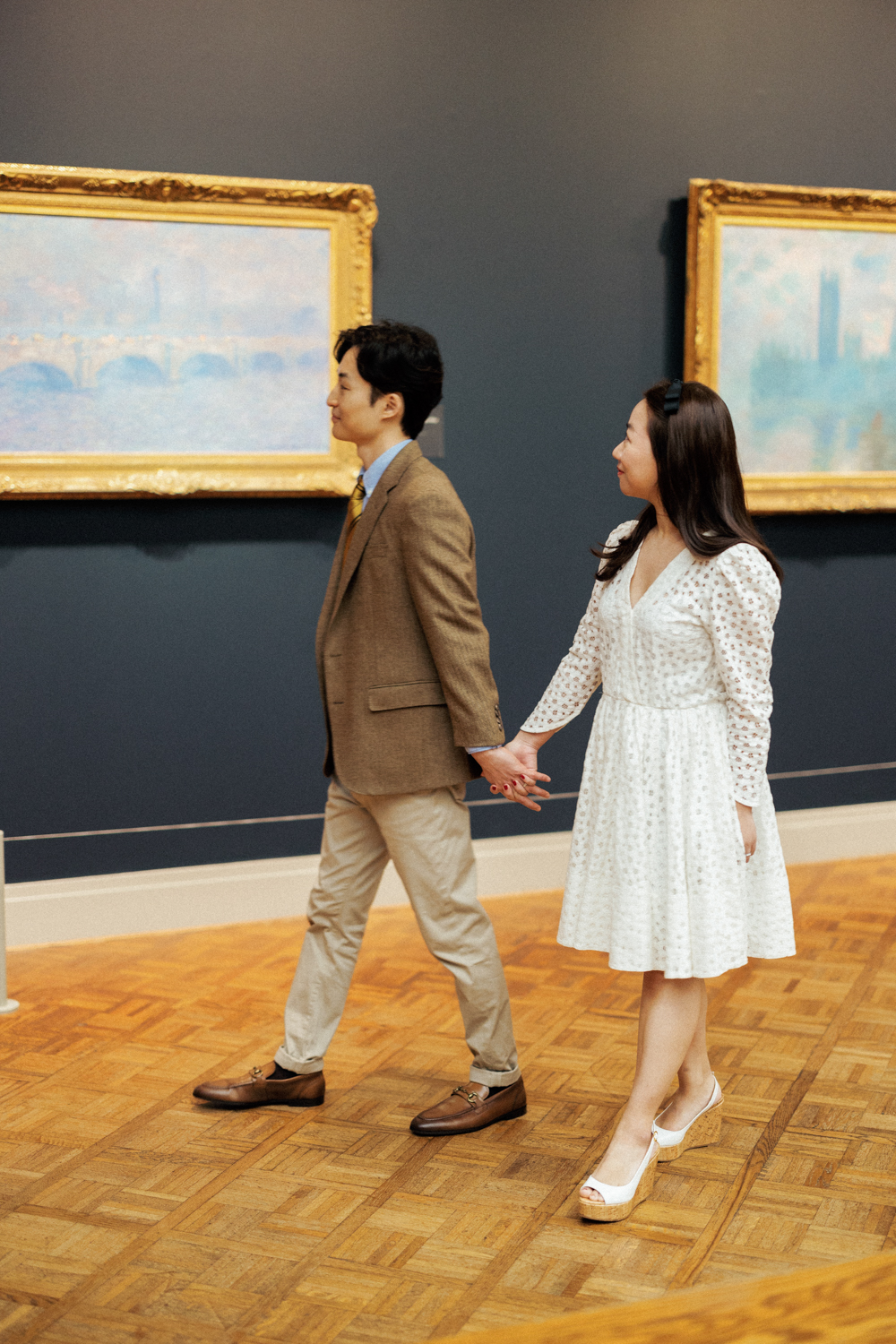 Couple walking through the Art Institute of Chicago for an engagement photo session.