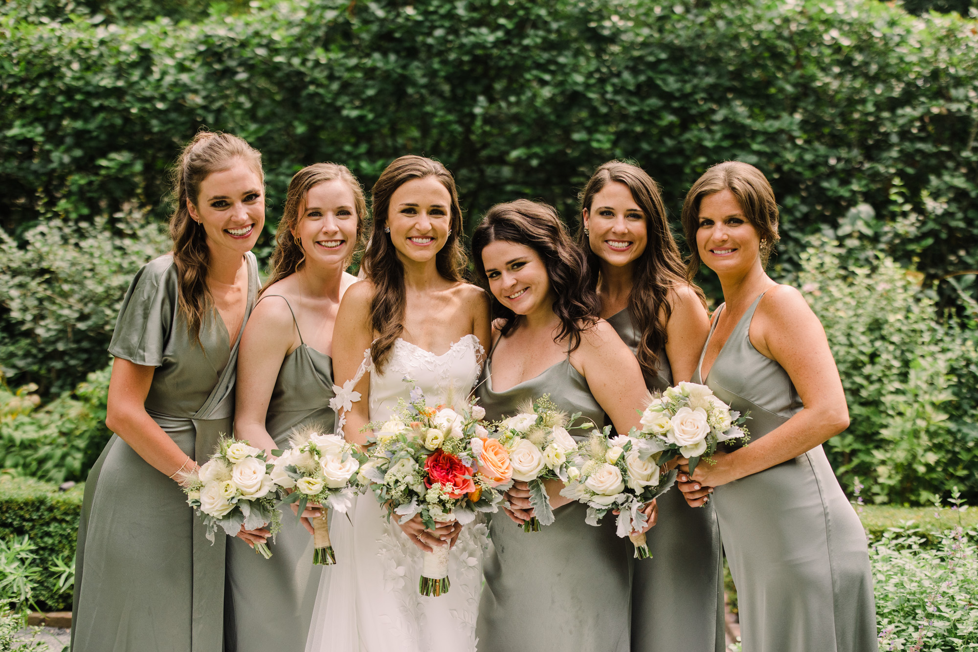 Bridesmaids in satin olive green gowns.