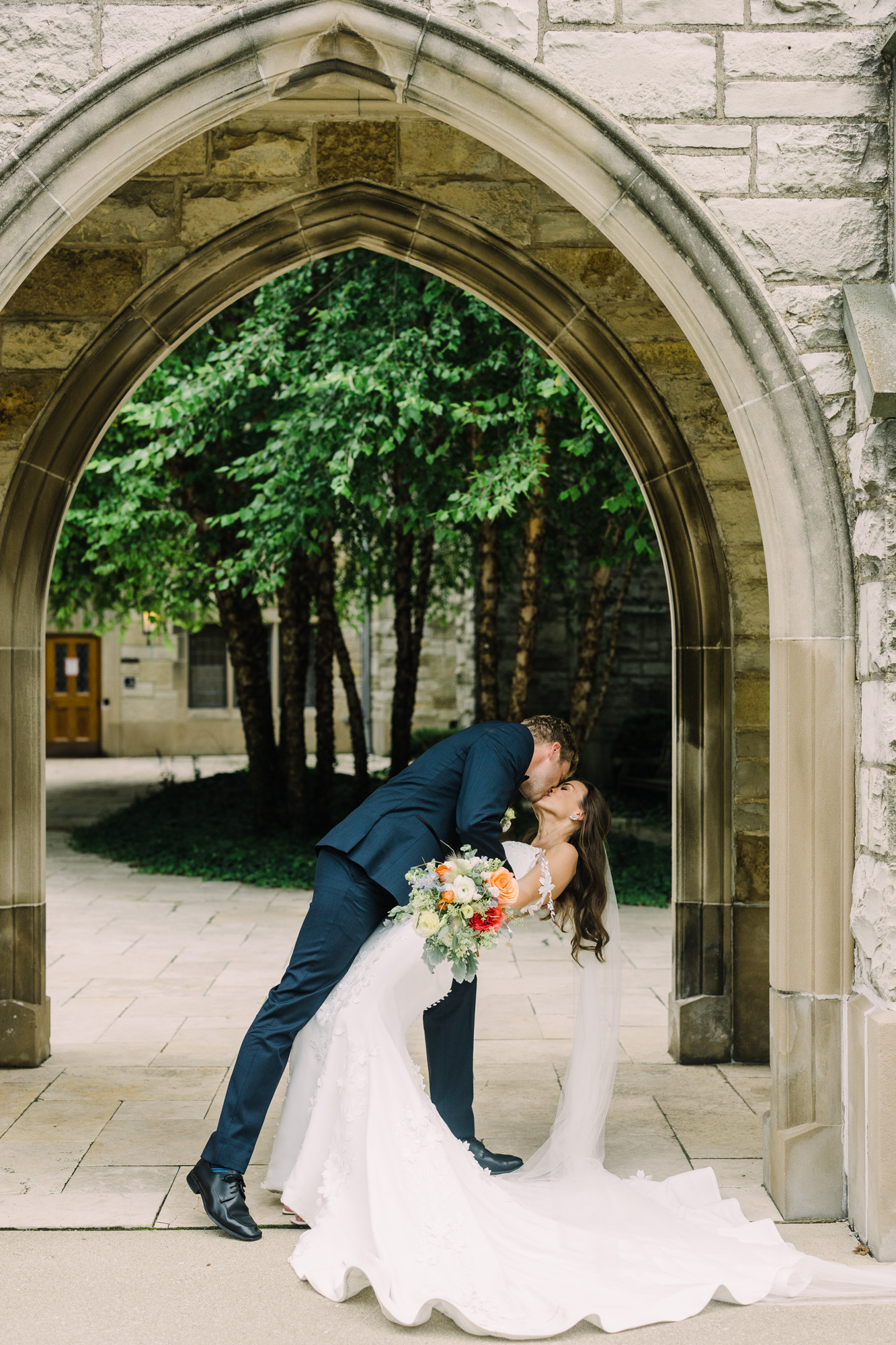 Bride and groom share a kiss under the arches of Alice Millar Chapel.