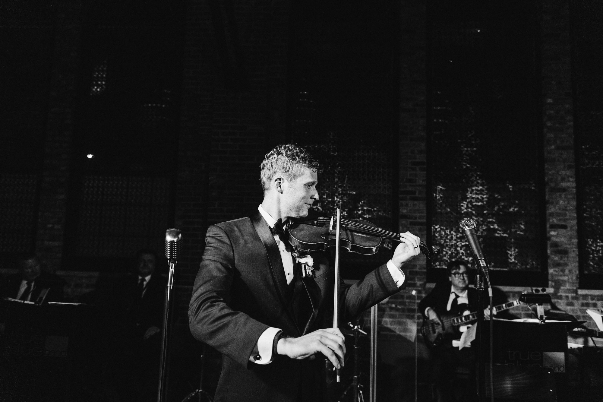 A groom plays his violin with the wedding band at City Hall in the West Loop.