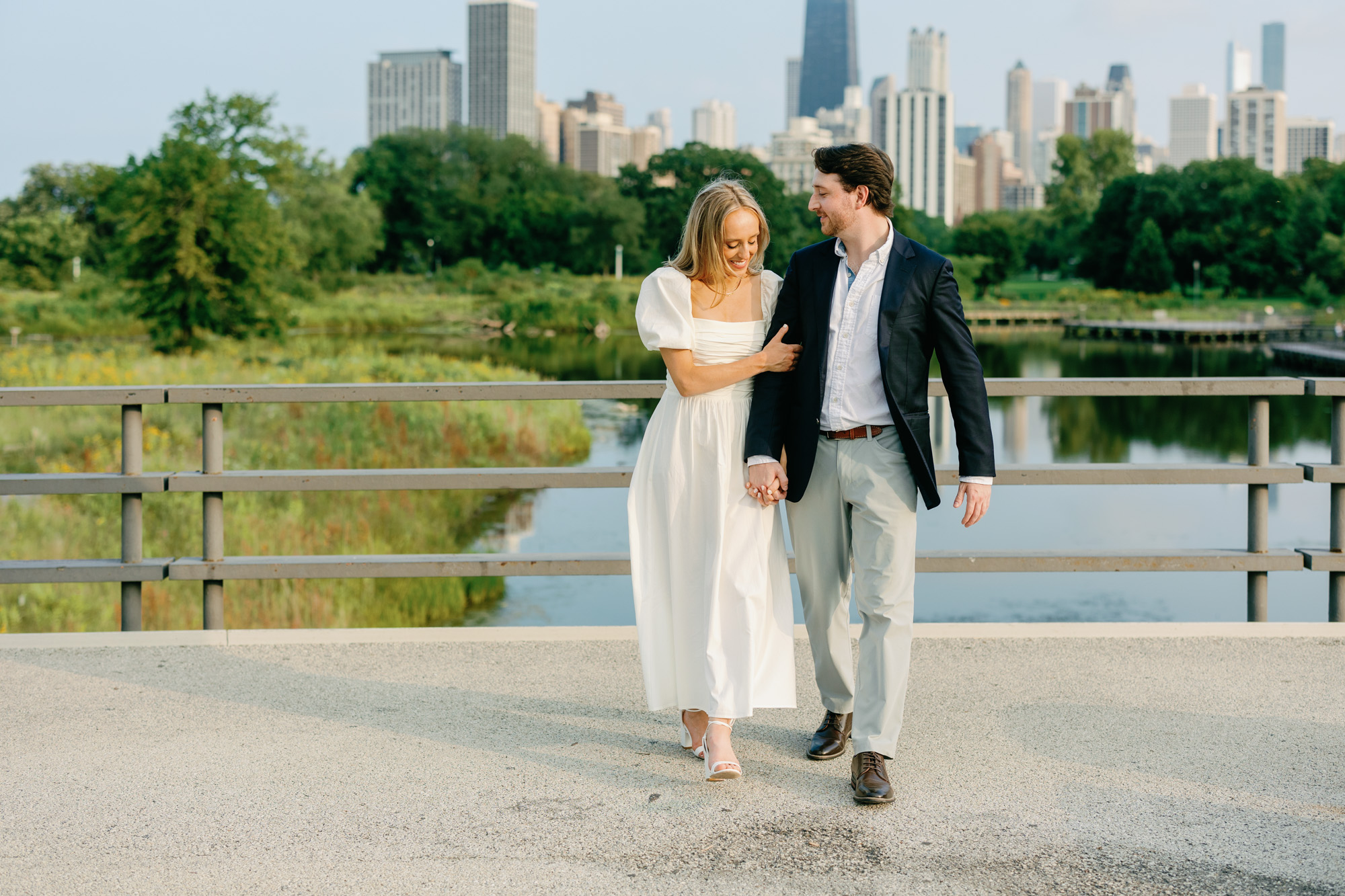 A couple walk together along Lincoln Park's Nature Boardwalk for an engagement photo.