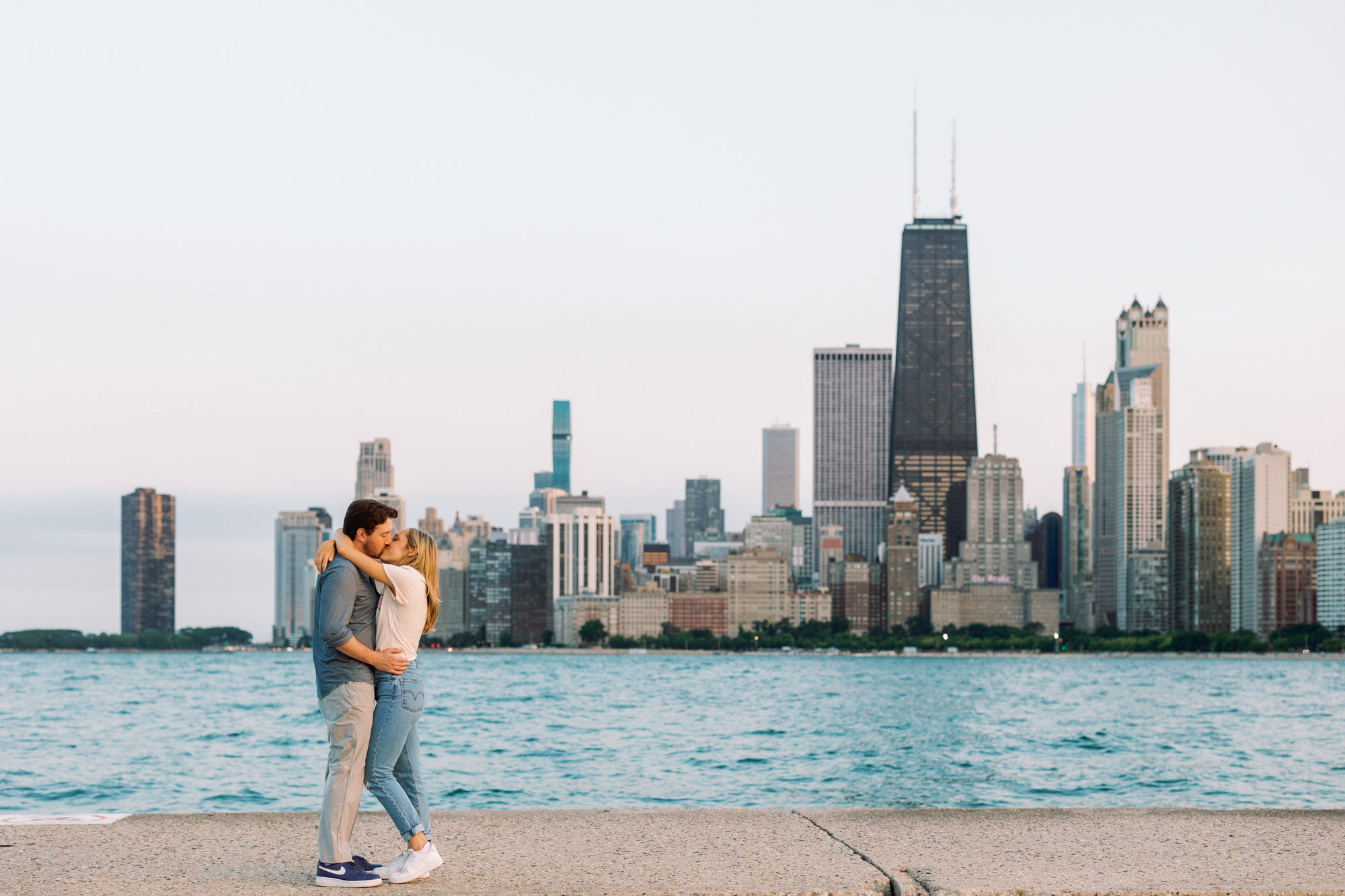A couple kiss in front of the Chicago skyline from North Avenue Beach.