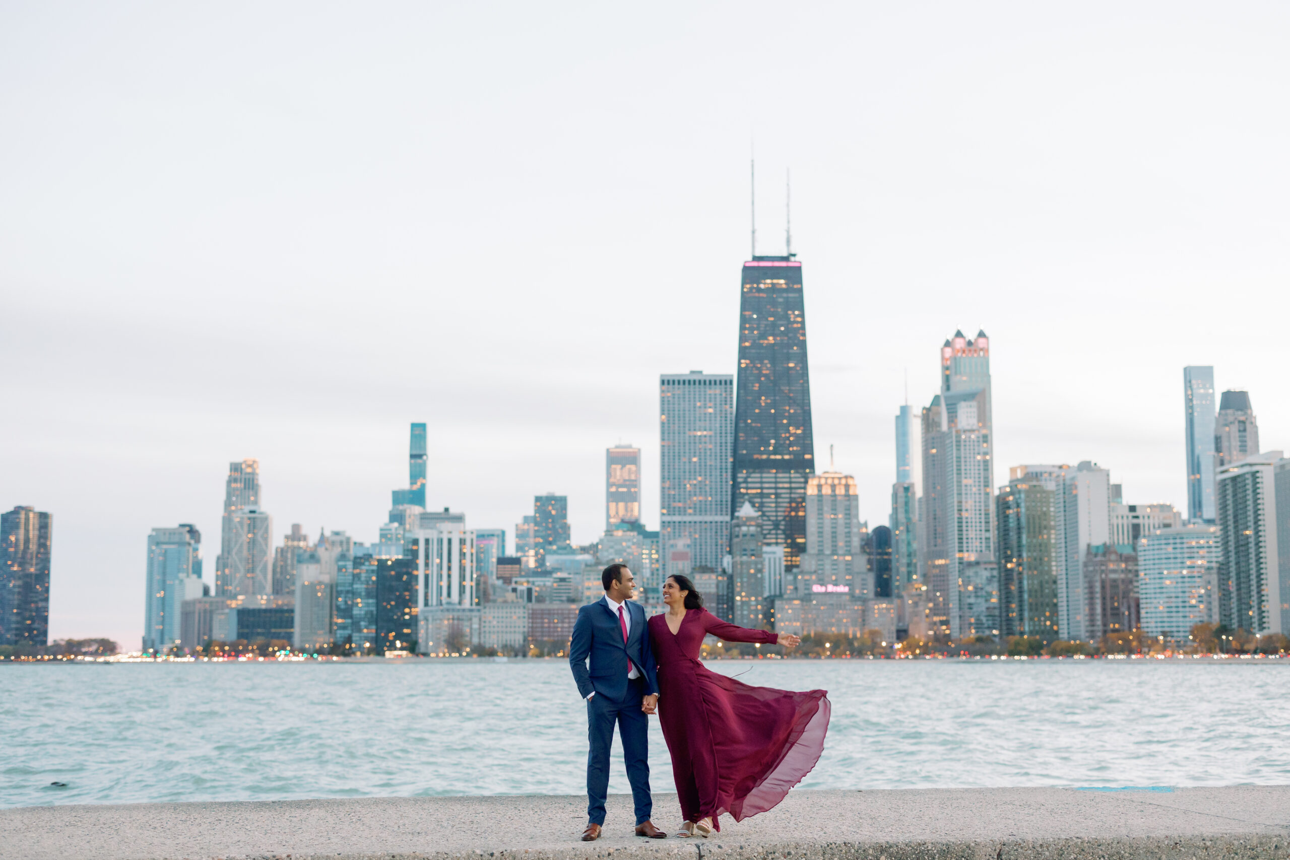 An engagement photo taken in front of the Chicago skyline at North Avenue Beach at sunset.
