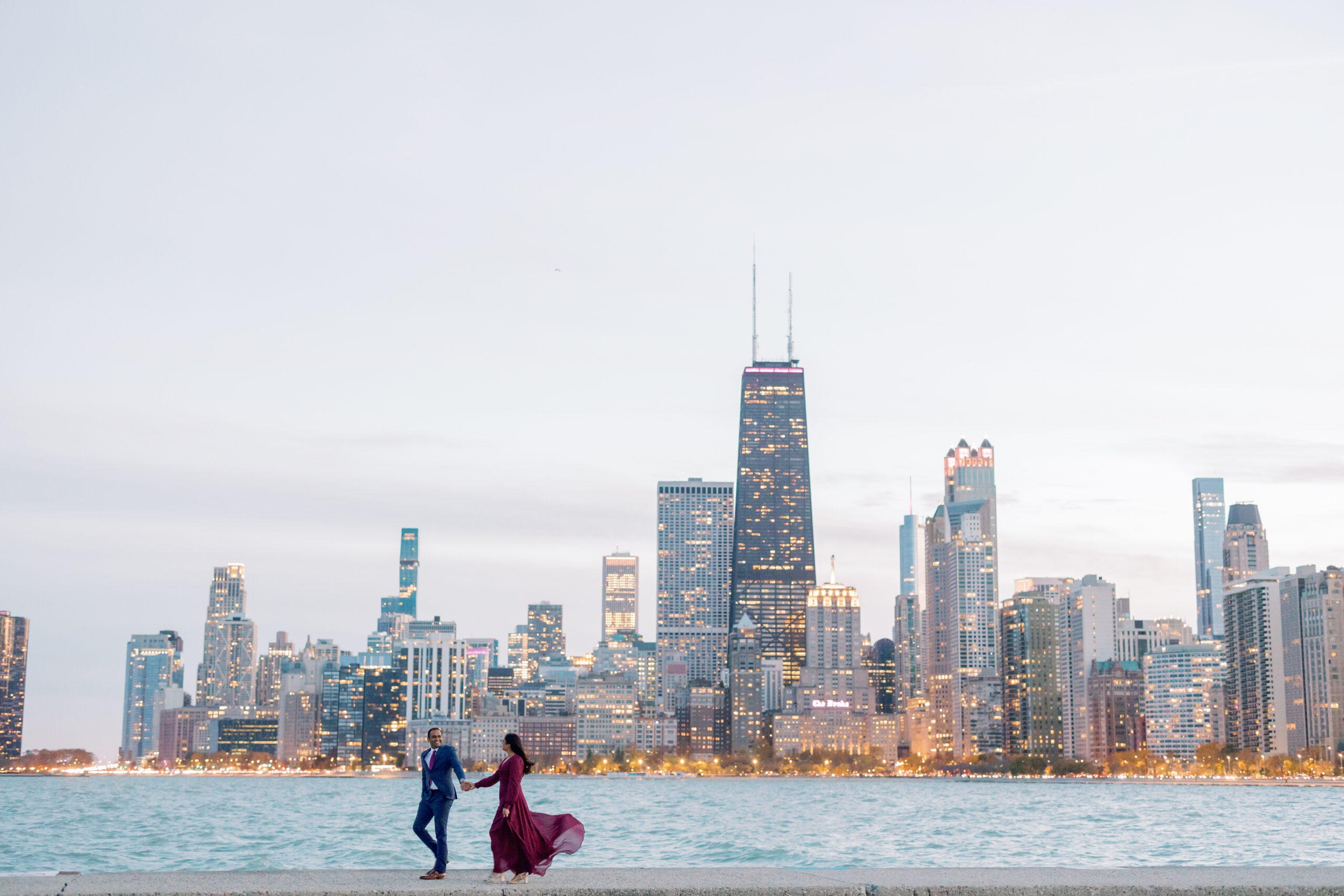 An engagement photo taken in front of the Chicago skyline at North Avenue Beach at sunset.
