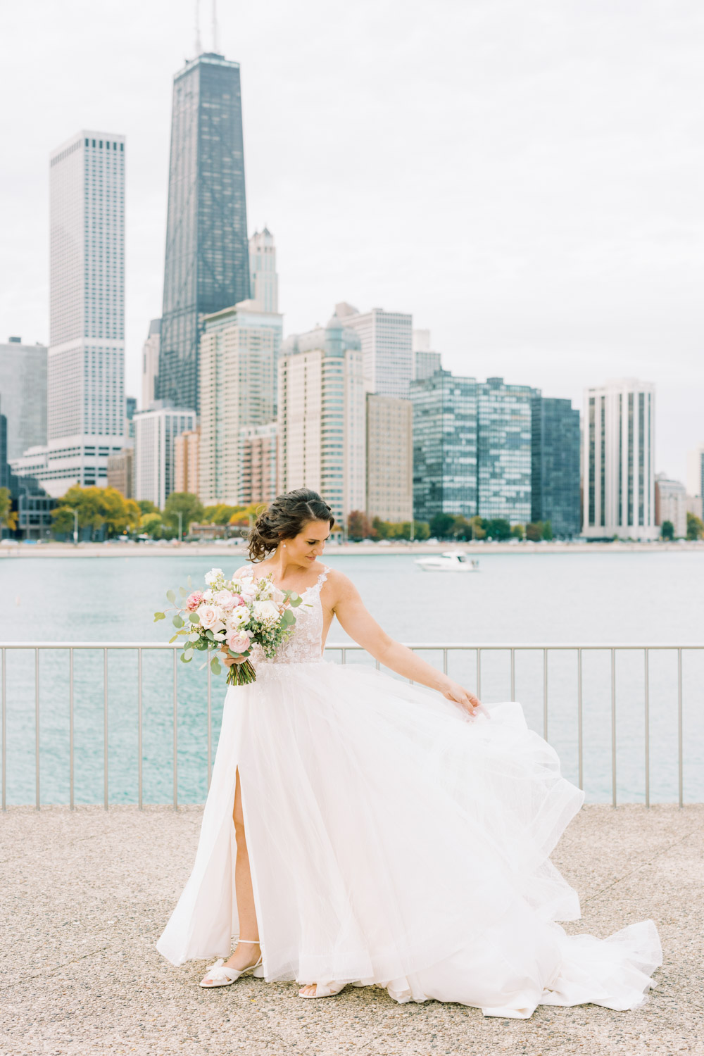 A bride poses in front of the Chicago skyline at Olive Park.