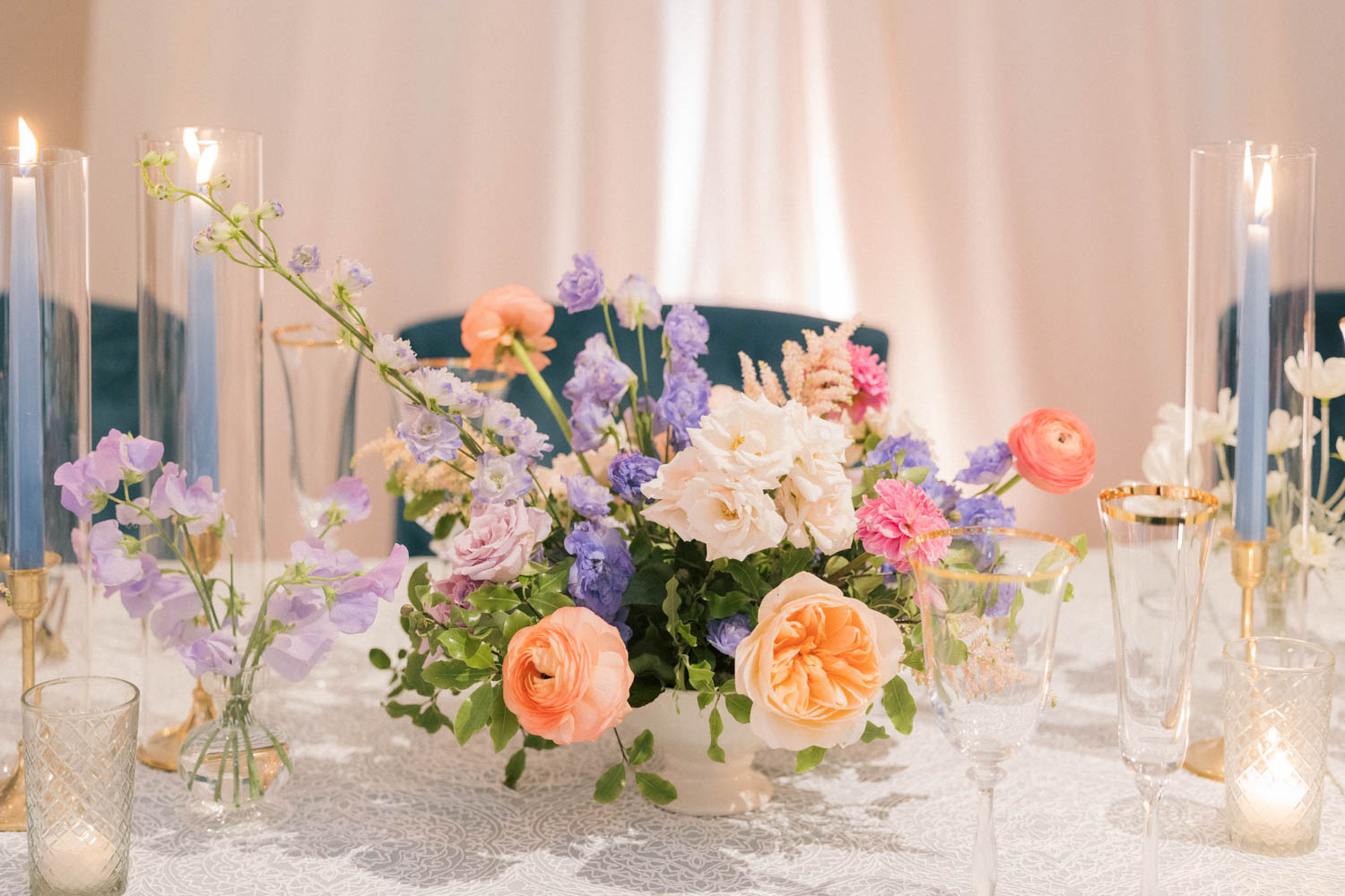 A beautiful wedding floral arrangement paired with blue tapered candles