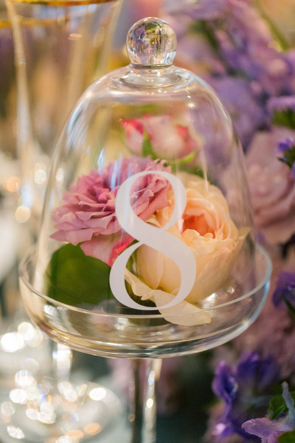 A closeup of a wedding reception table number cloche.