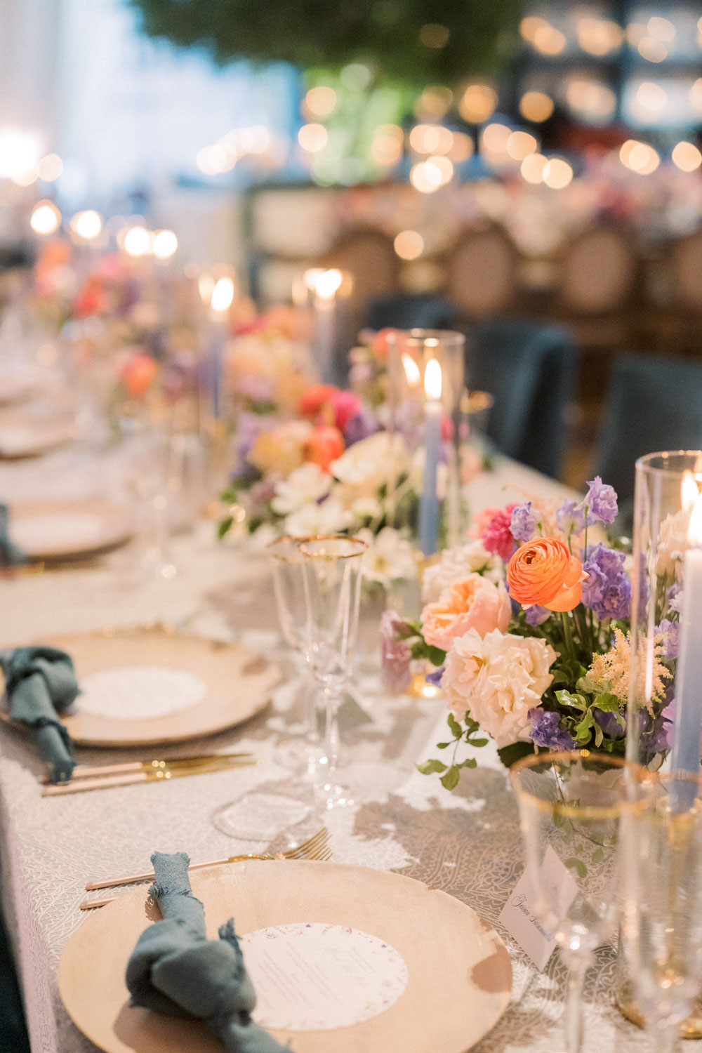 The most beautiful wedding reception with vivid floral arrangements and blue tapered candles.