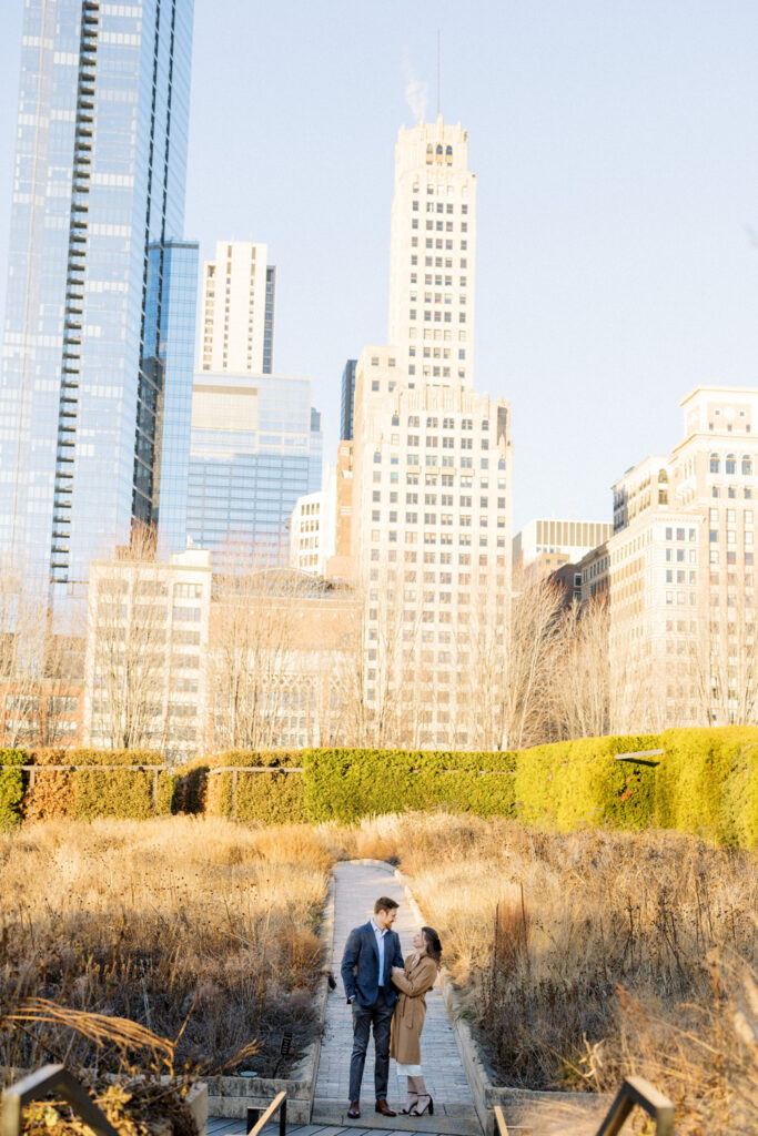 A wide engagement photo taken in Chicago's Lurie Garden highlighting the city backdrop