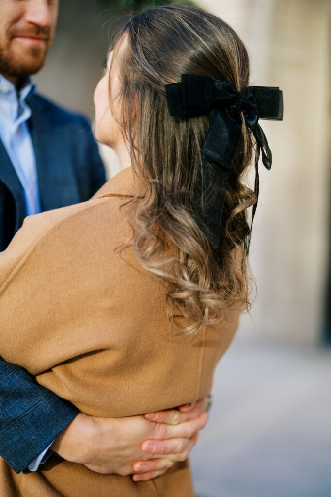 A bride wears a black velvet bow in her hair during her engagement session