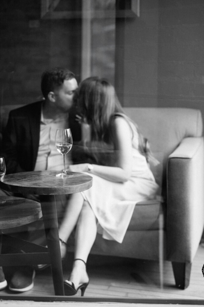 Candid moment between engaged couple revisiting a local wine bar in Lincoln Park for their personalized engagement session