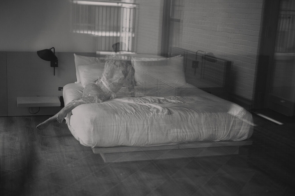 Artistic blurred boudoir image woman on bed editorial style photography
