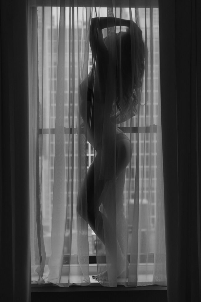 Female silhouette behind sheer curtains window boudoir photography