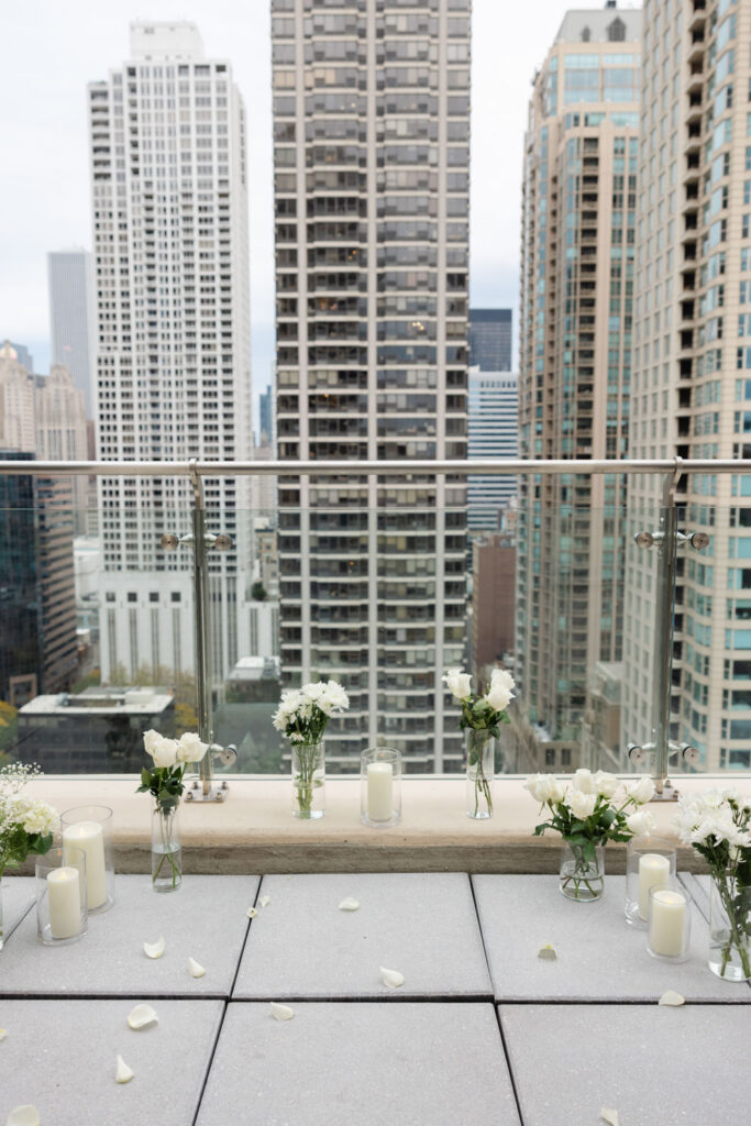 Candles and petals lining a modern rooftop terrace in downtown Chicago before a proposal.