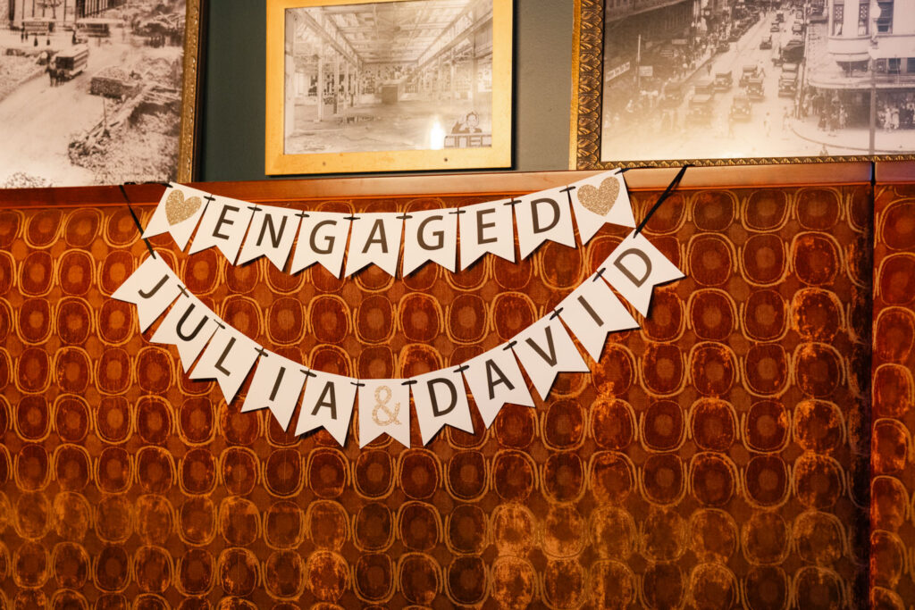 Engagement banner hanging inside Chicago bar decorated for surprise party.