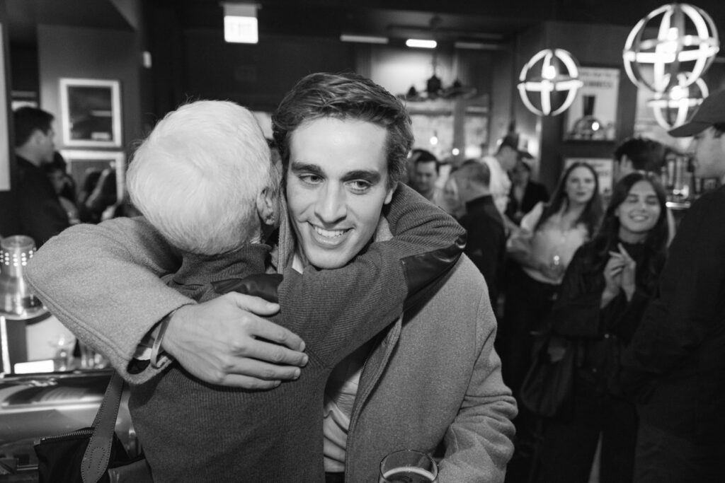 Man hugging family member after surprise proposal celebration at Pippins in Chicago.