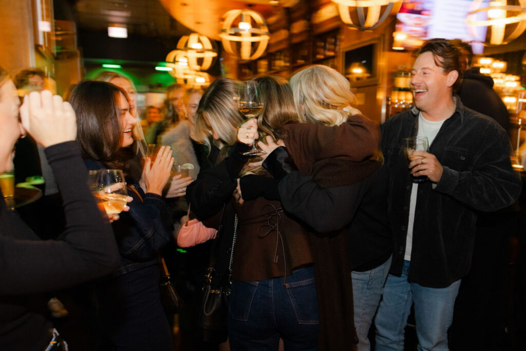 Group of friends smiling and celebrating at engagement party in downtown Chicago.