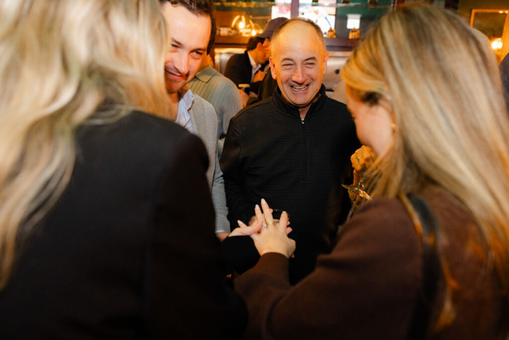 Group of friends smiling and celebrating at engagement party in downtown Chicago.