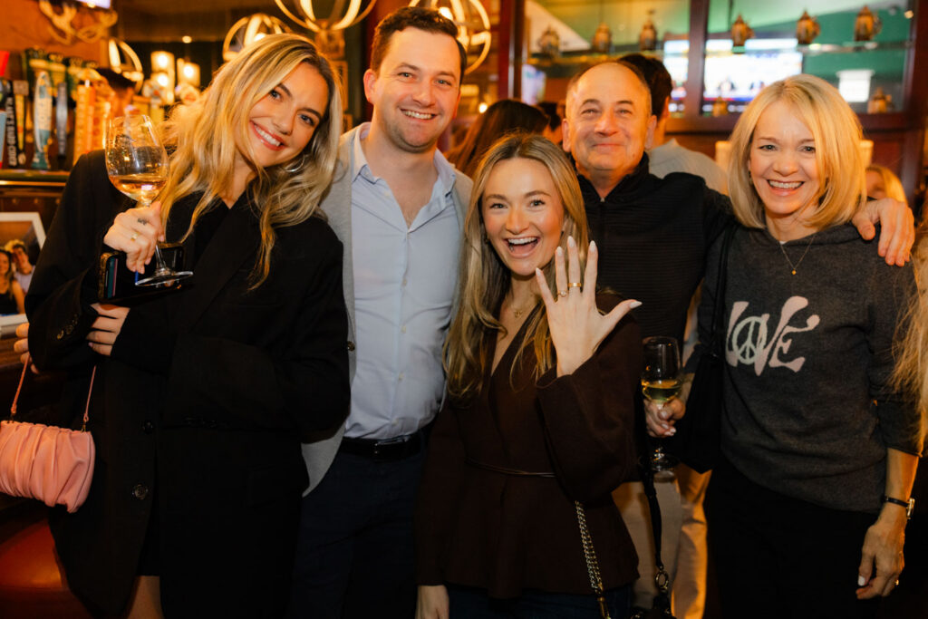 Group of friends smiling and celebrating at engagement party in downtown Chicago.