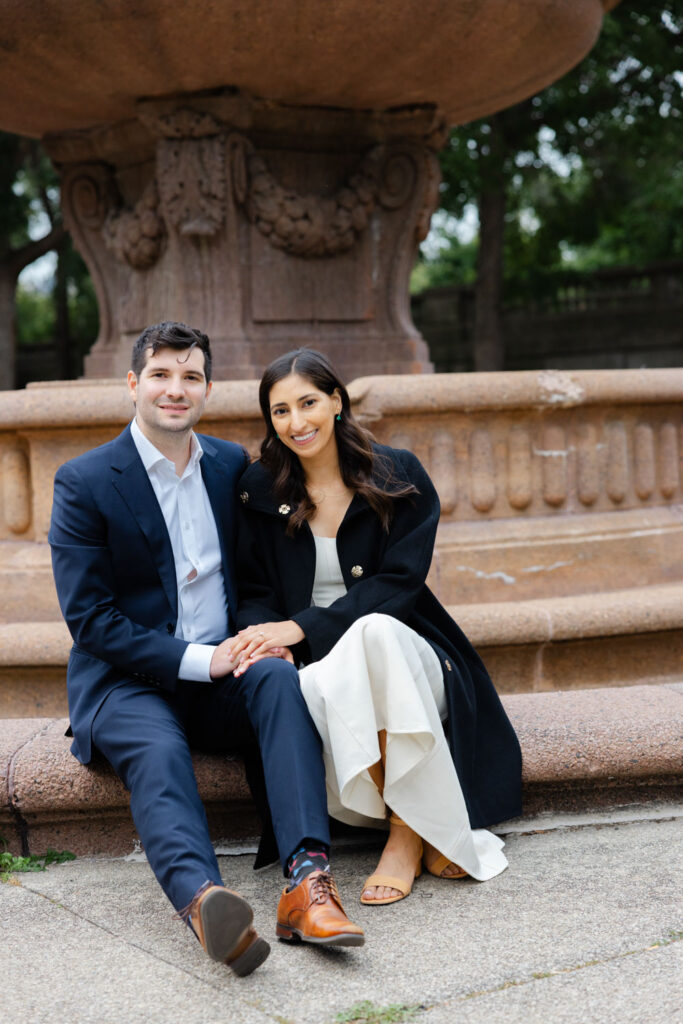 Couple sitting together beside stone fountain in Chicago garden