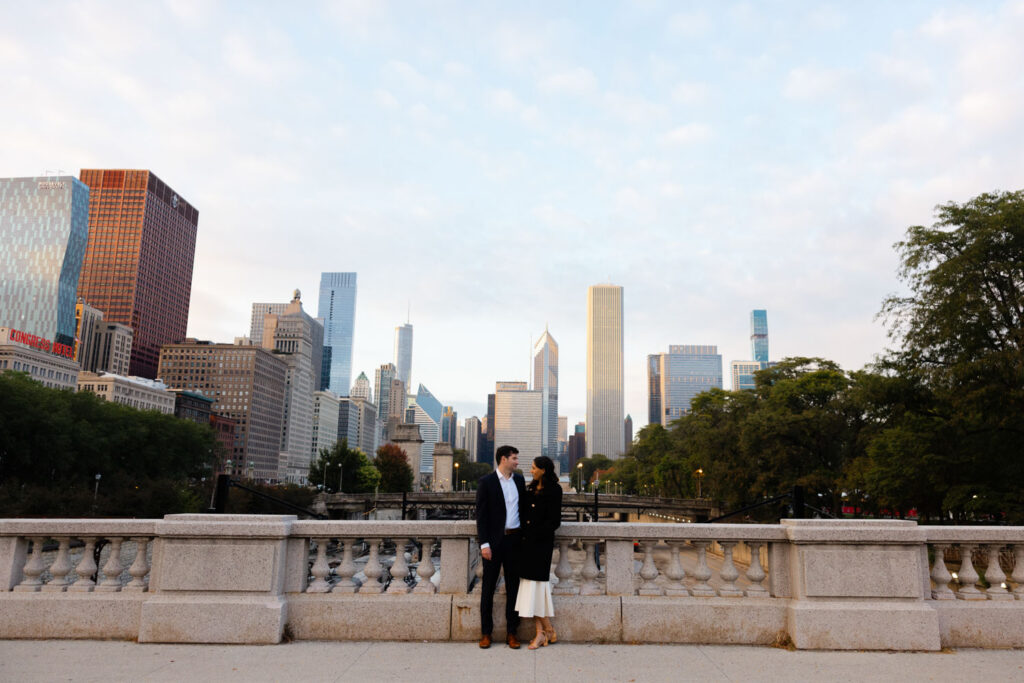 Couple standing together with Chicago skyline in the distance along Michigan Avenue