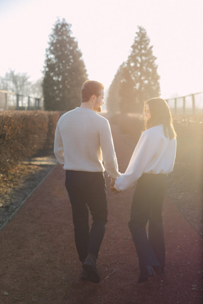 Couple walking away together on garden path at Elawa Farm sunrise engagement session