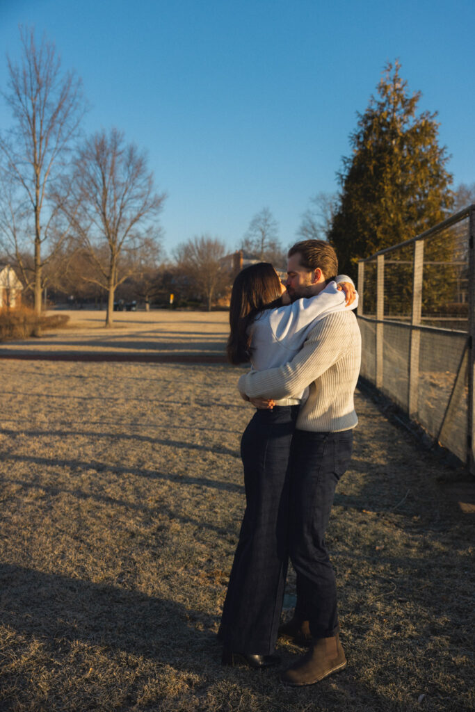 Couple hugging in open field at Elawa Farm engagement session