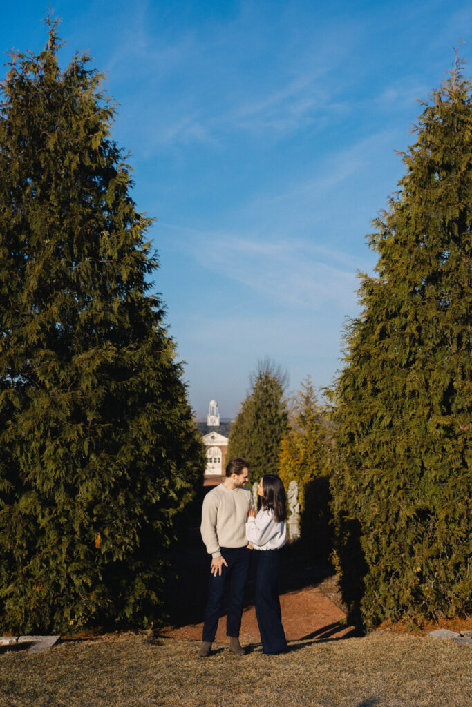 Couple walking between tall trees at Elawa Farm Lake Forest engagement session