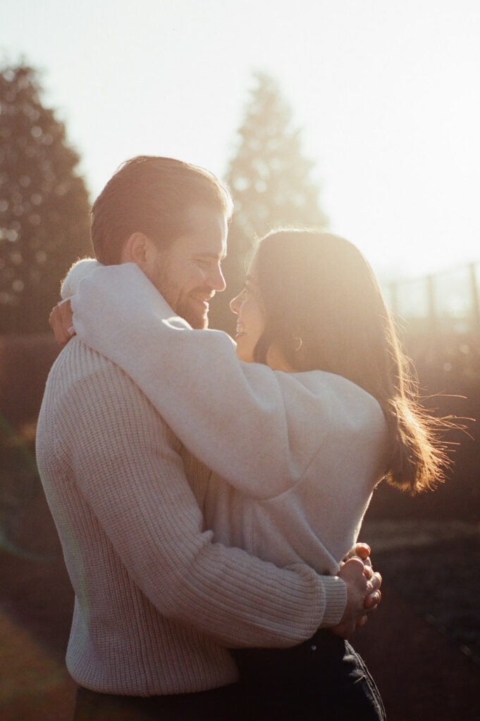 Close up of couple embracing in golden sunrise light at Elawa Farm captured on film