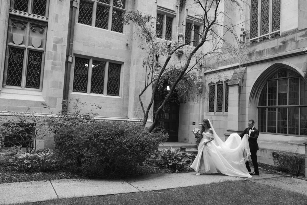Black and white portrait of bride and groom walking through the courtyard of Fourth Presbyterian Church