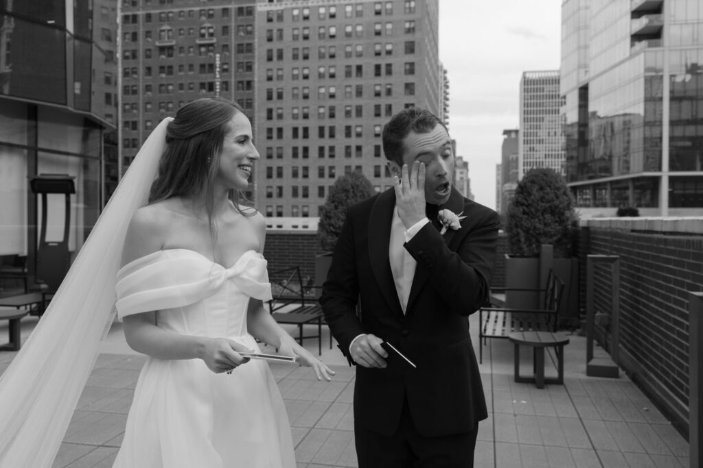 Groom wiping tears away from his face during their first look