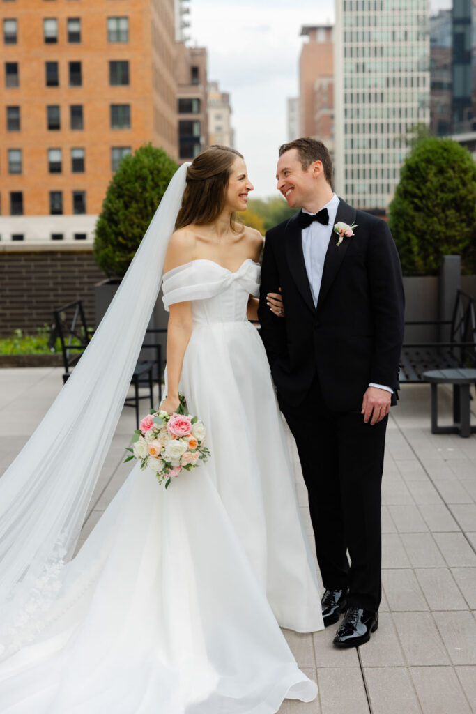 Bride and groom walking together across rooftop terrace in downtown Chicago