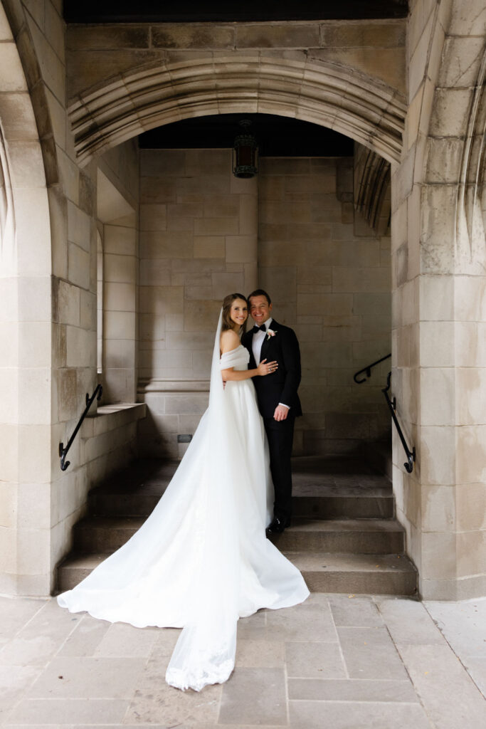Bride and groom posing on stone staircase at Fourth Presbyterian Church