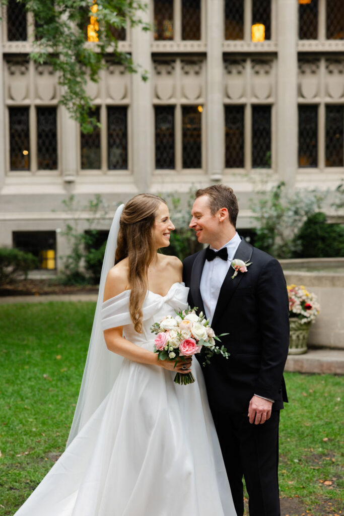 Bride and groom smiling together in the ivy courtyard at Fourth Presbyterian Church in Chicago