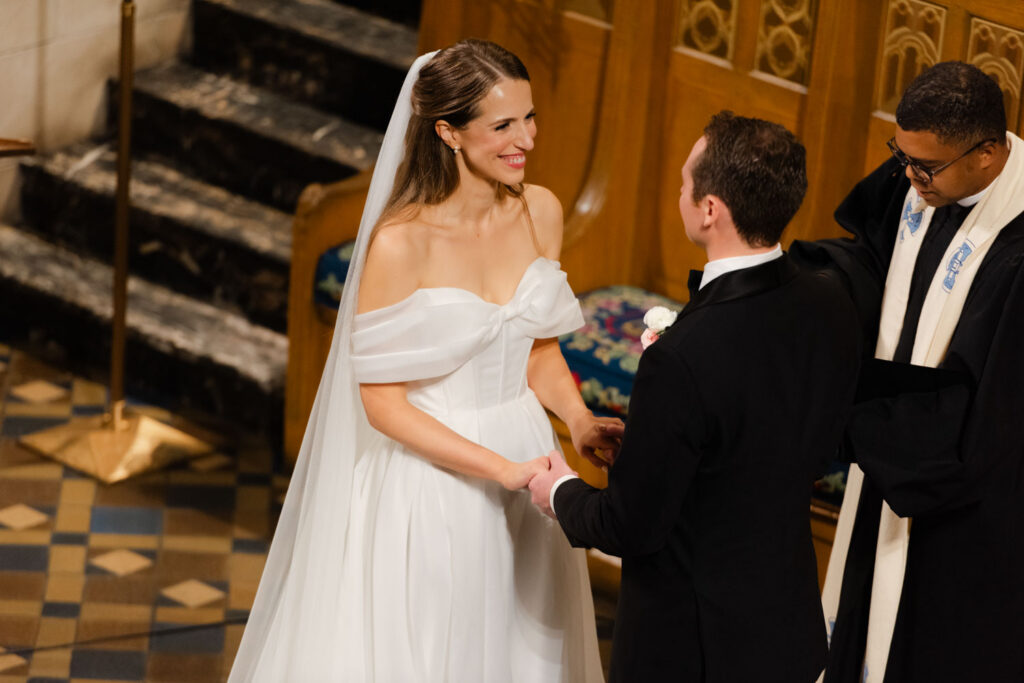 Bride and groom holding hands during ceremony at Fourth Presbyterian Church in Chicago