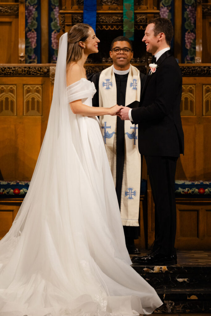 Bride and groom holding hands during ceremony at Fourth Presbyterian Church in Chicago
