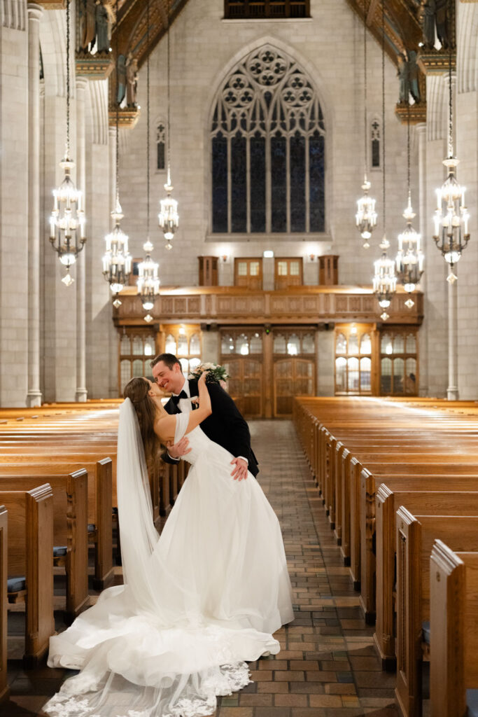Groom twirling bride during joyful recessional down the church aisle