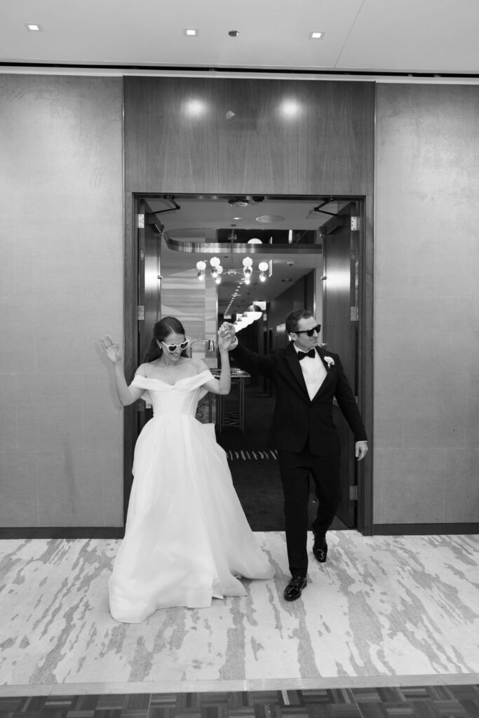 Bride and groom running into reception space together