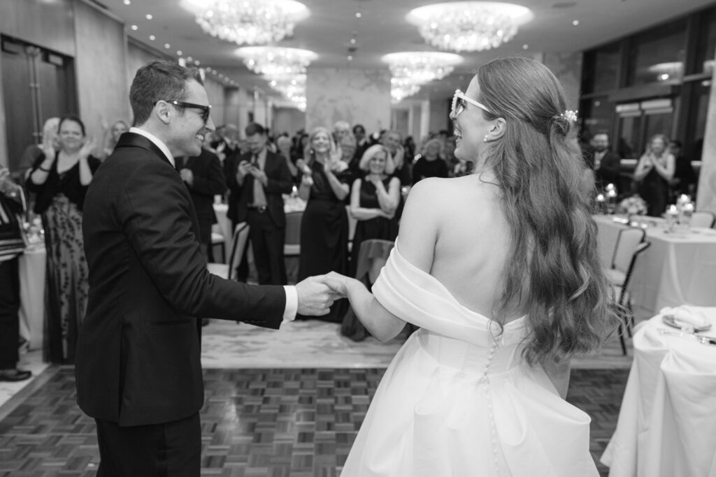 Bride and groom running into reception space together
