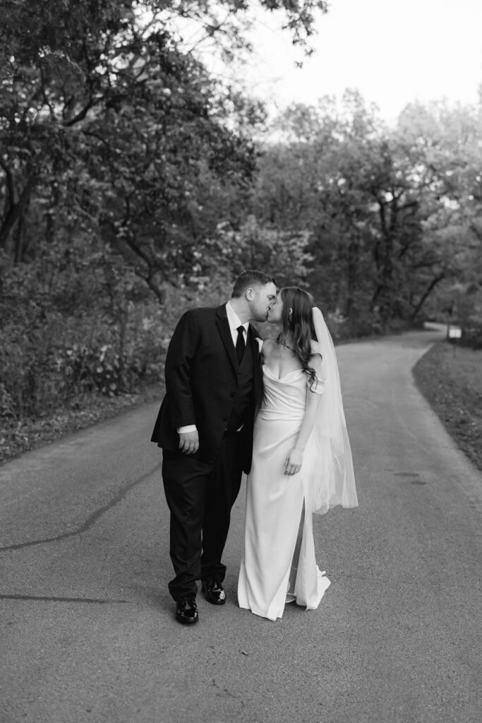 Newlywed couple walking together through autumn trees at Morton Arboretum